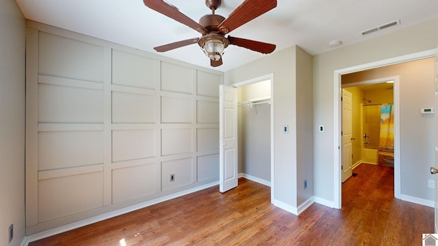 unfurnished bedroom with ceiling fan, a closet, and wood-type flooring