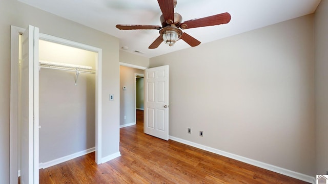 unfurnished bedroom with ceiling fan, a closet, and light wood-type flooring