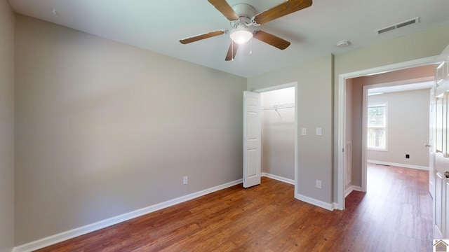 unfurnished bedroom featuring ceiling fan, a closet, and hardwood / wood-style flooring