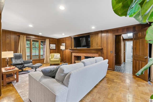 living room featuring a brick fireplace, wooden walls, and light parquet flooring