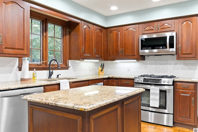 kitchen featuring light stone counters, appliances with stainless steel finishes, tasteful backsplash, and sink