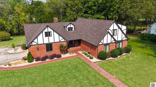 tudor-style house featuring a front lawn