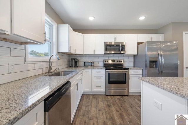 kitchen featuring dark hardwood / wood-style floors, sink, stainless steel appliances, and white cabinets