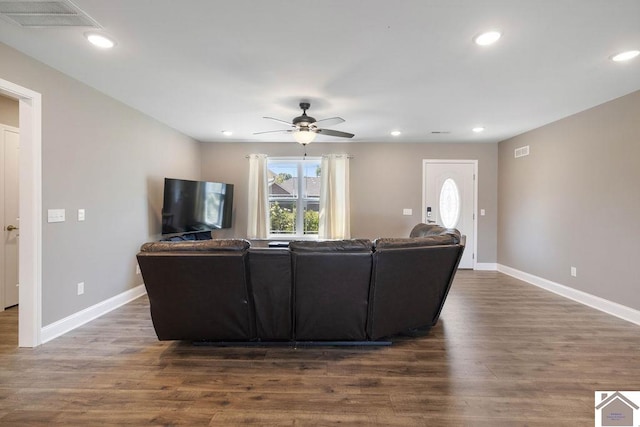 living room featuring ceiling fan and dark hardwood / wood-style floors