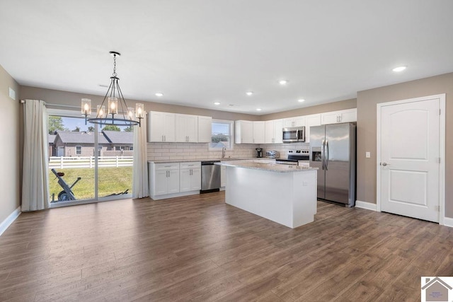 2216 Traci Dr, Murray, KY 42071 - kitchen with appliances with stainless steel finishes, baseboards, white cabinetry, a chandelier, and plenty of natural light