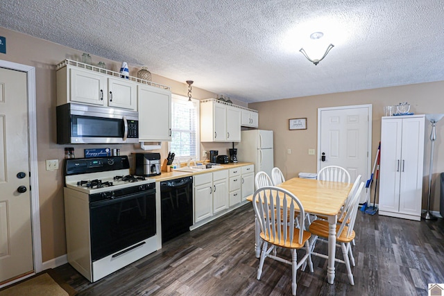 kitchen with white appliances, white cabinetry, and dark hardwood / wood-style flooring