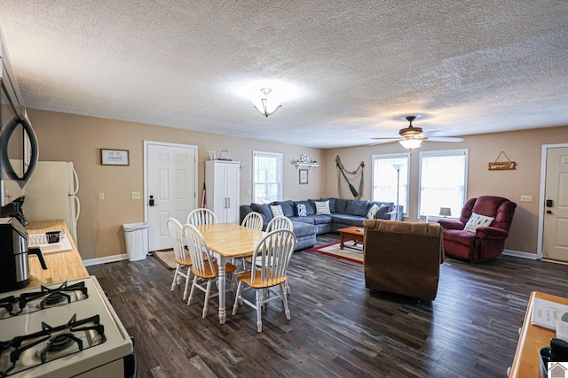 dining room with ceiling fan, a textured ceiling, and dark wood-type flooring