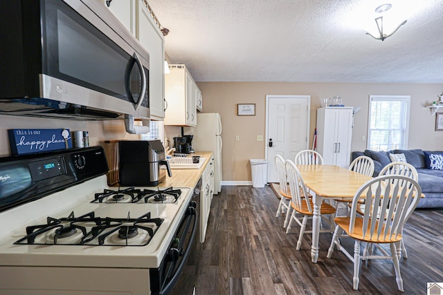 kitchen featuring white cabinetry, a textured ceiling, white range with gas cooktop, and dark hardwood / wood-style flooring