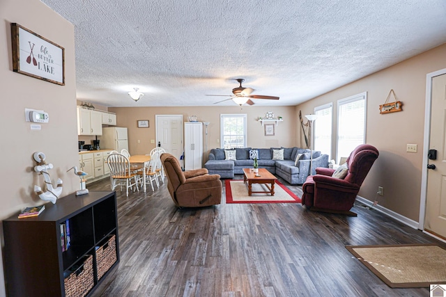 living room with ceiling fan, a textured ceiling, and dark hardwood / wood-style floors