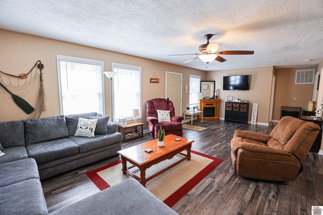 living room featuring a textured ceiling, ceiling fan, and dark hardwood / wood-style flooring