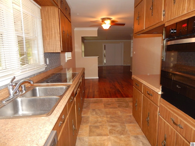 kitchen featuring light hardwood / wood-style floors, sink, black electric cooktop, ceiling fan, and stainless steel oven