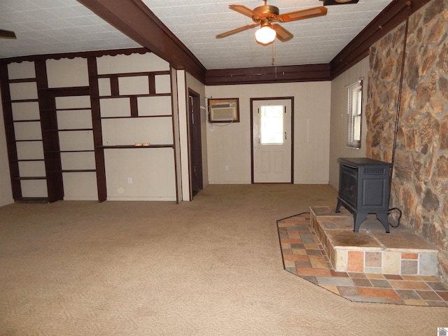 unfurnished living room featuring ceiling fan, light carpet, a wall mounted air conditioner, and a wood stove