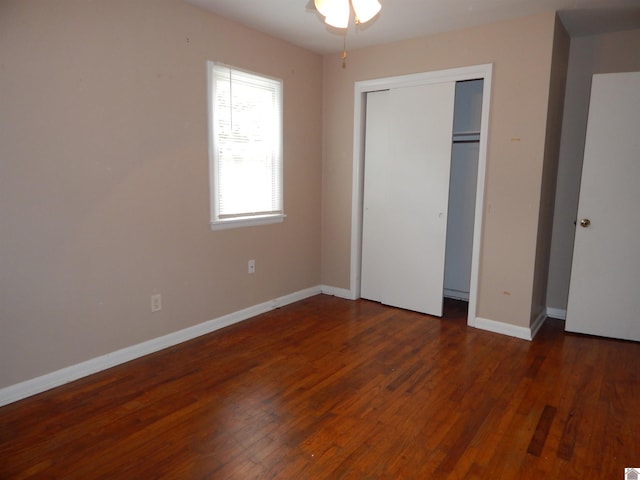 unfurnished bedroom with dark hardwood / wood-style flooring and a closet