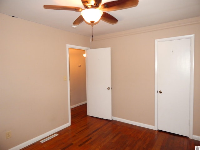 empty room featuring ceiling fan and dark hardwood / wood-style flooring