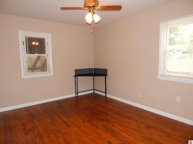 empty room with ceiling fan and dark hardwood / wood-style flooring