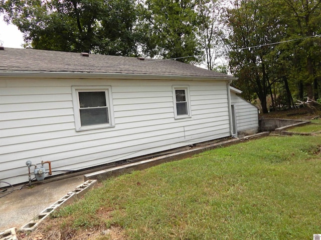 view of side of home with a yard