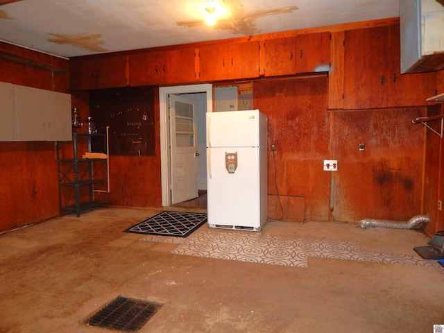 interior space with wood walls and white refrigerator