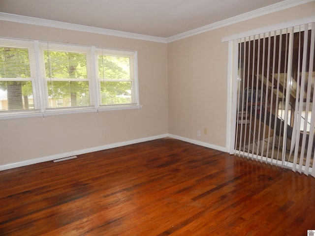 spare room featuring ornamental molding and dark wood-type flooring