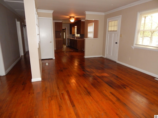 unfurnished living room featuring ornamental molding, ceiling fan, and dark wood-type flooring