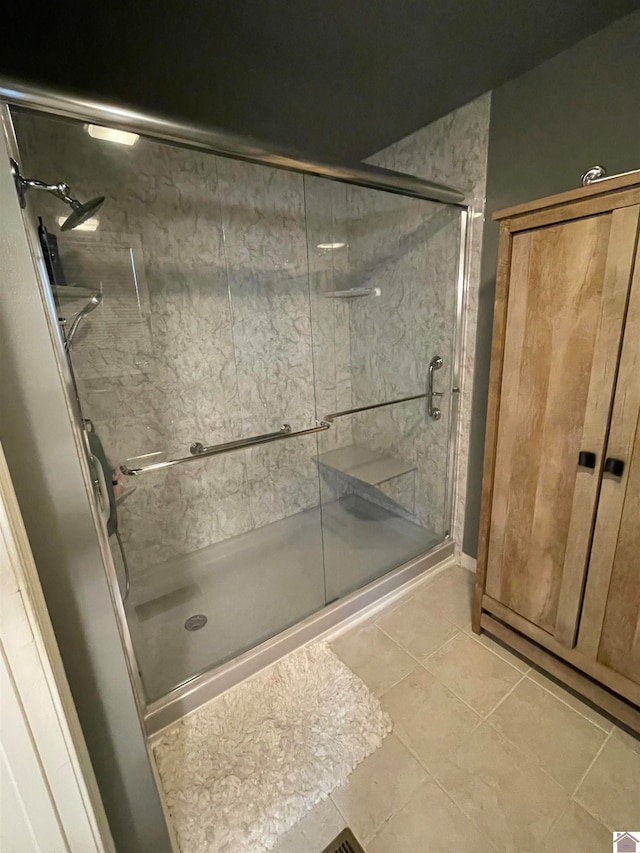 bathroom with tile patterned floors and an enclosed shower