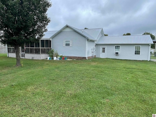 rear view of house with a sunroom, cooling unit, and a yard