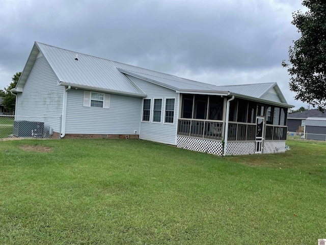 rear view of property featuring a sunroom and a lawn