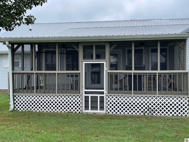 back of property with a sunroom and a yard