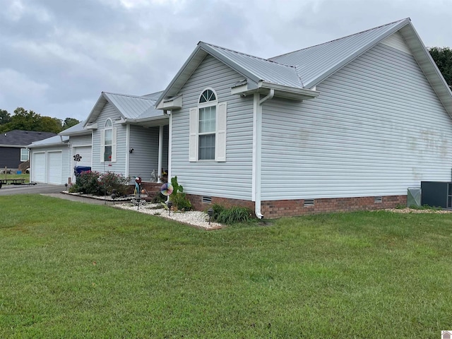 view of front of home featuring central AC unit, a front yard, and a garage