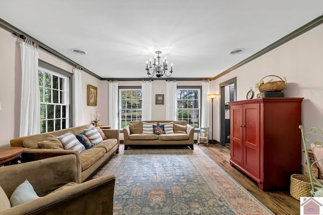 living room featuring an inviting chandelier, crown molding, and dark hardwood / wood-style floors