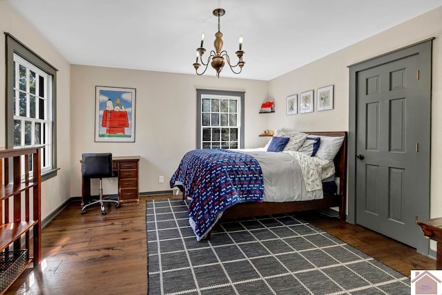 bedroom with a notable chandelier and dark hardwood / wood-style flooring