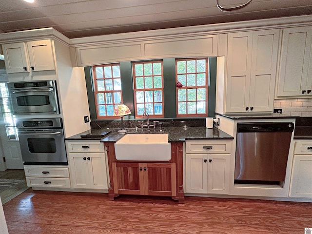 kitchen with appliances with stainless steel finishes, light hardwood / wood-style floors, sink, and tasteful backsplash