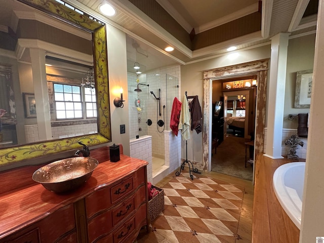 bathroom with crown molding, tiled shower, and vanity