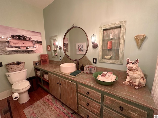 bathroom with wood-type flooring, vanity, and toilet