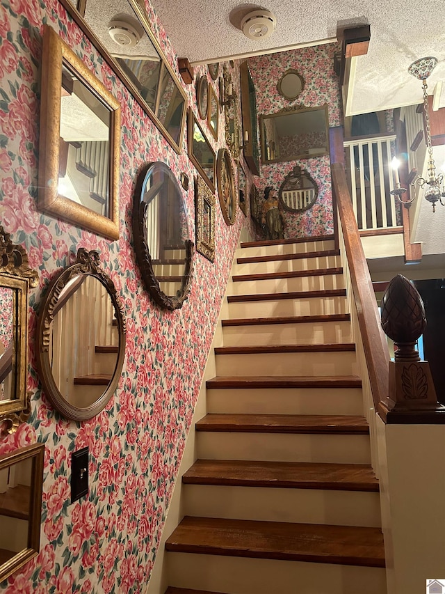 stairs featuring a textured ceiling