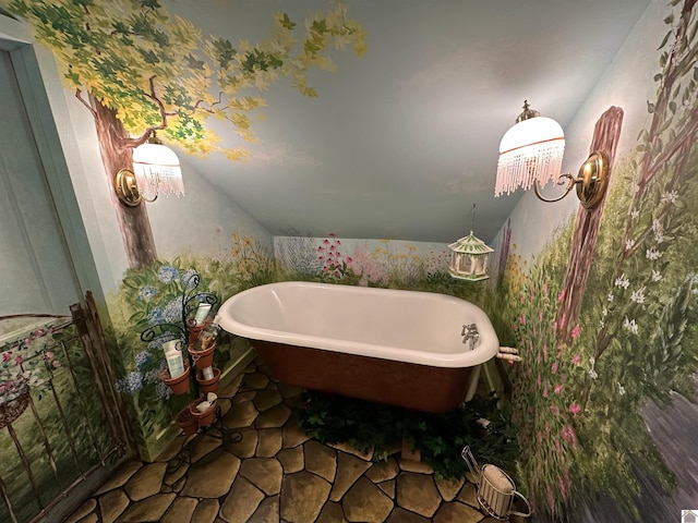 bathroom with vaulted ceiling, a tub, and tile patterned floors