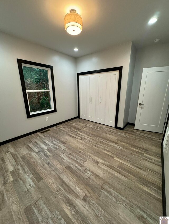 unfurnished bedroom with a closet and light hardwood / wood-style floors