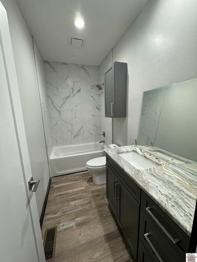 full bathroom featuring tiled shower / bath combo, vanity, toilet, and hardwood / wood-style flooring