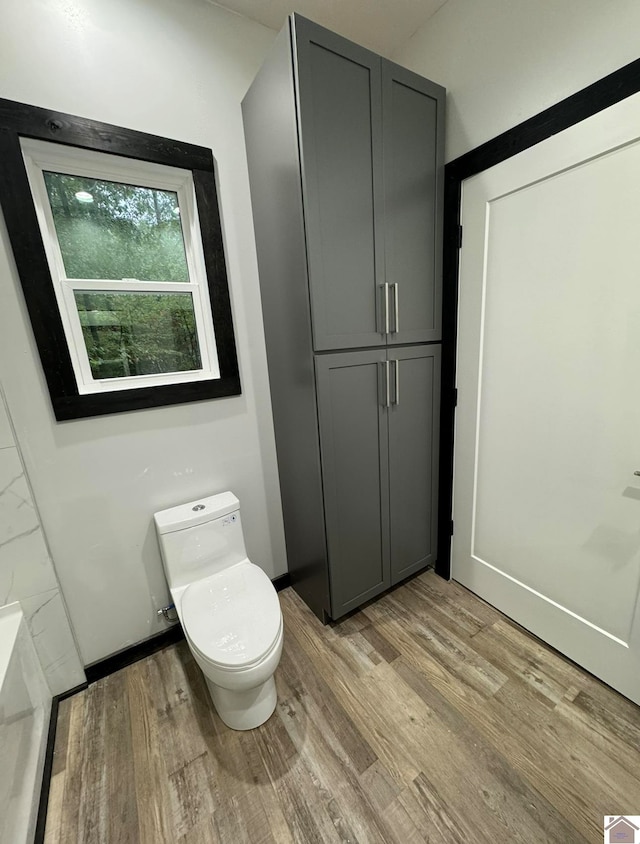 bathroom featuring hardwood / wood-style floors and toilet