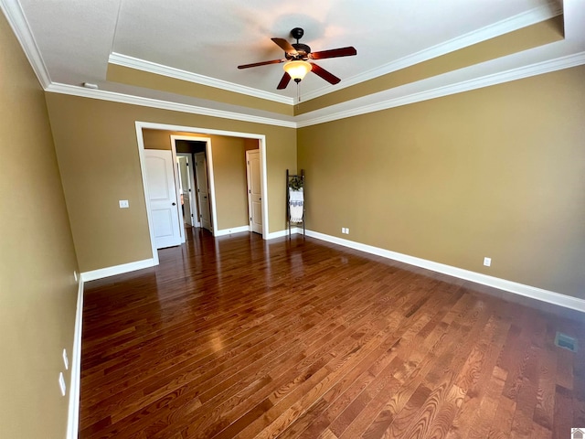 unfurnished room with wood-type flooring, crown molding, ceiling fan, and a raised ceiling