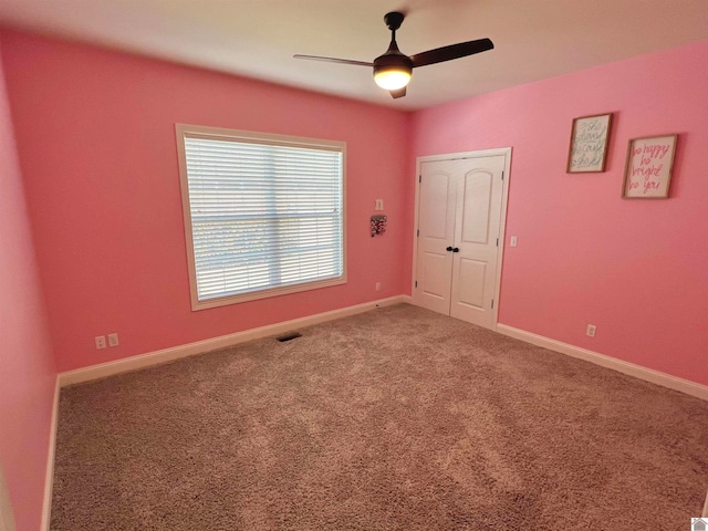 carpeted empty room featuring ceiling fan