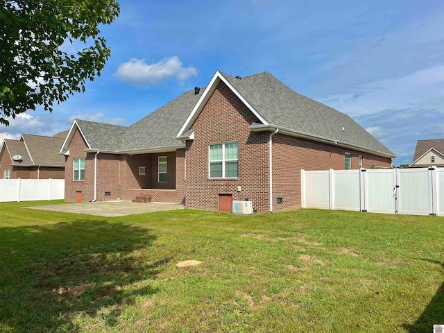 back of house featuring central AC unit, a lawn, and a patio area