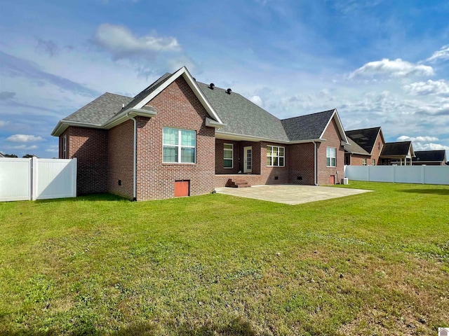 back of property featuring a lawn and a patio