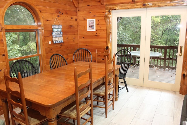 dining room featuring wood walls and a wealth of natural light