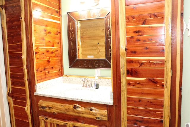 bathroom featuring wood walls and vanity