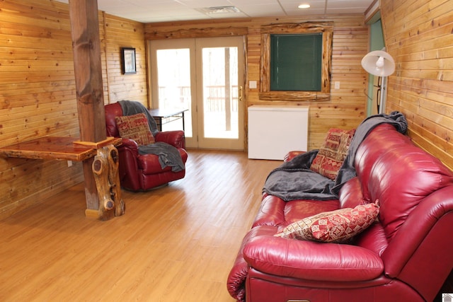 living room featuring light wood-type flooring and wooden walls