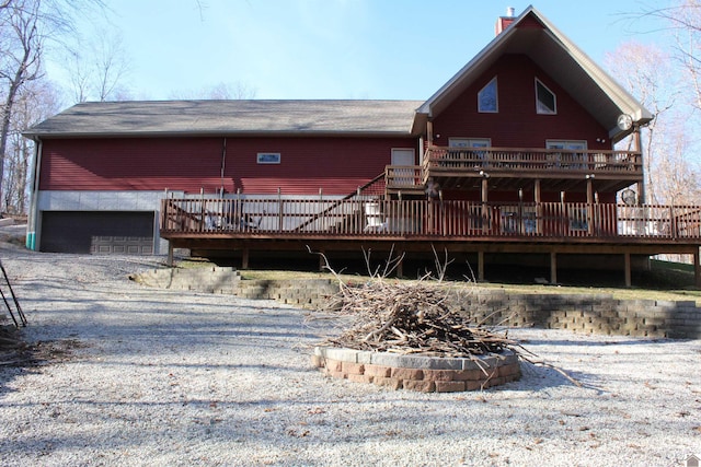 rear view of house with a garage and a wooden deck