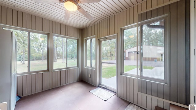 unfurnished sunroom featuring ceiling fan and plenty of natural light