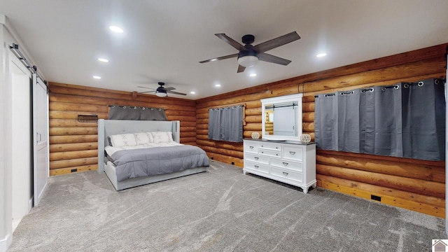 bedroom featuring ceiling fan, dark colored carpet, a barn door, and log walls