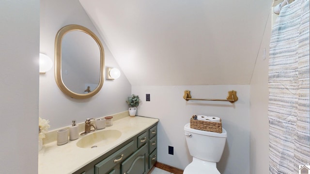 bathroom featuring lofted ceiling, vanity, and toilet