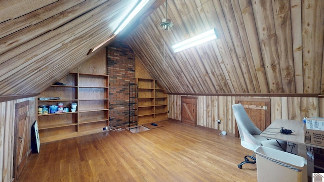 unfurnished office with lofted ceiling, wood-type flooring, wood walls, and built in features